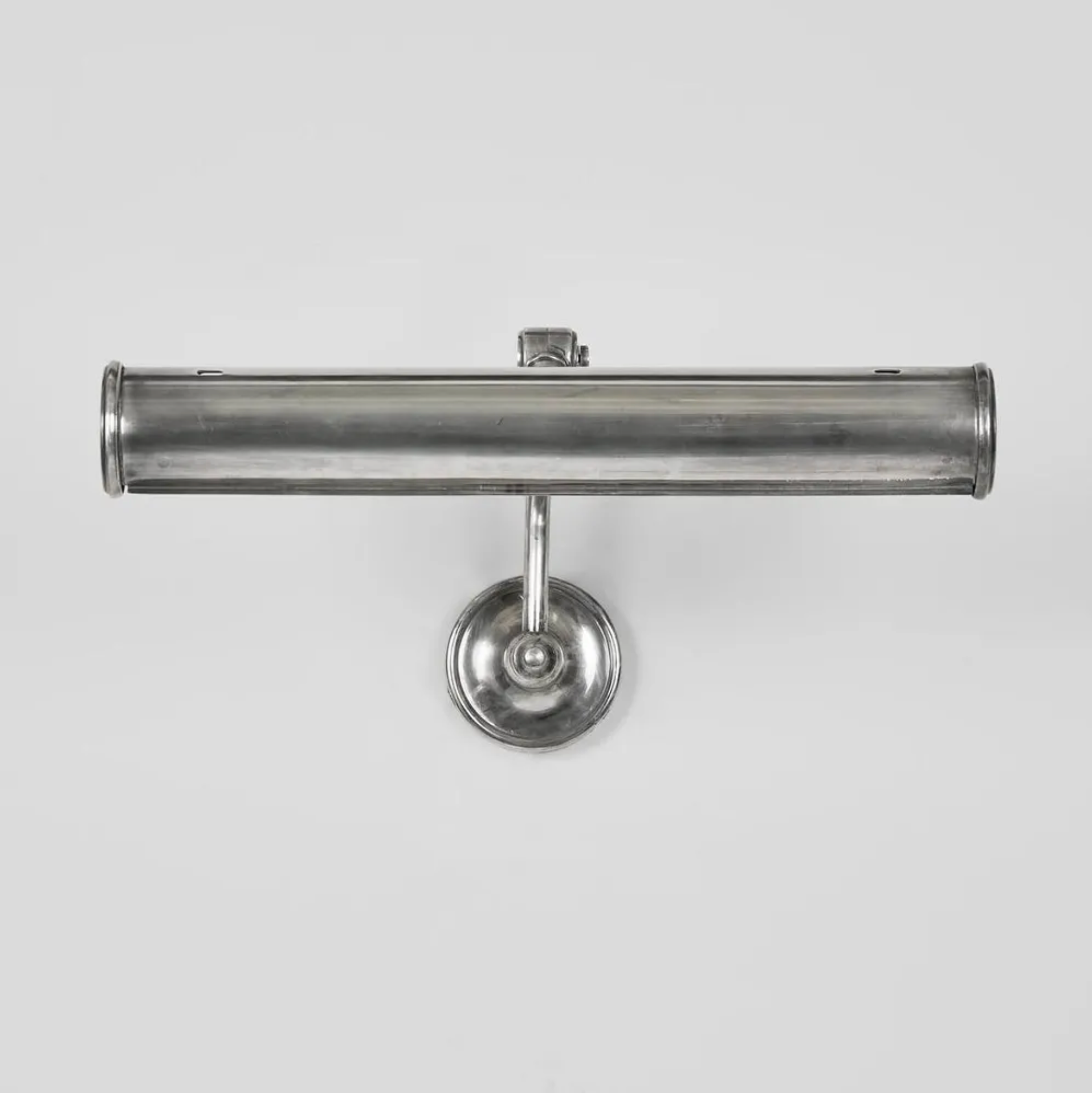 Metallic wall-mounted lamp on a light gray background