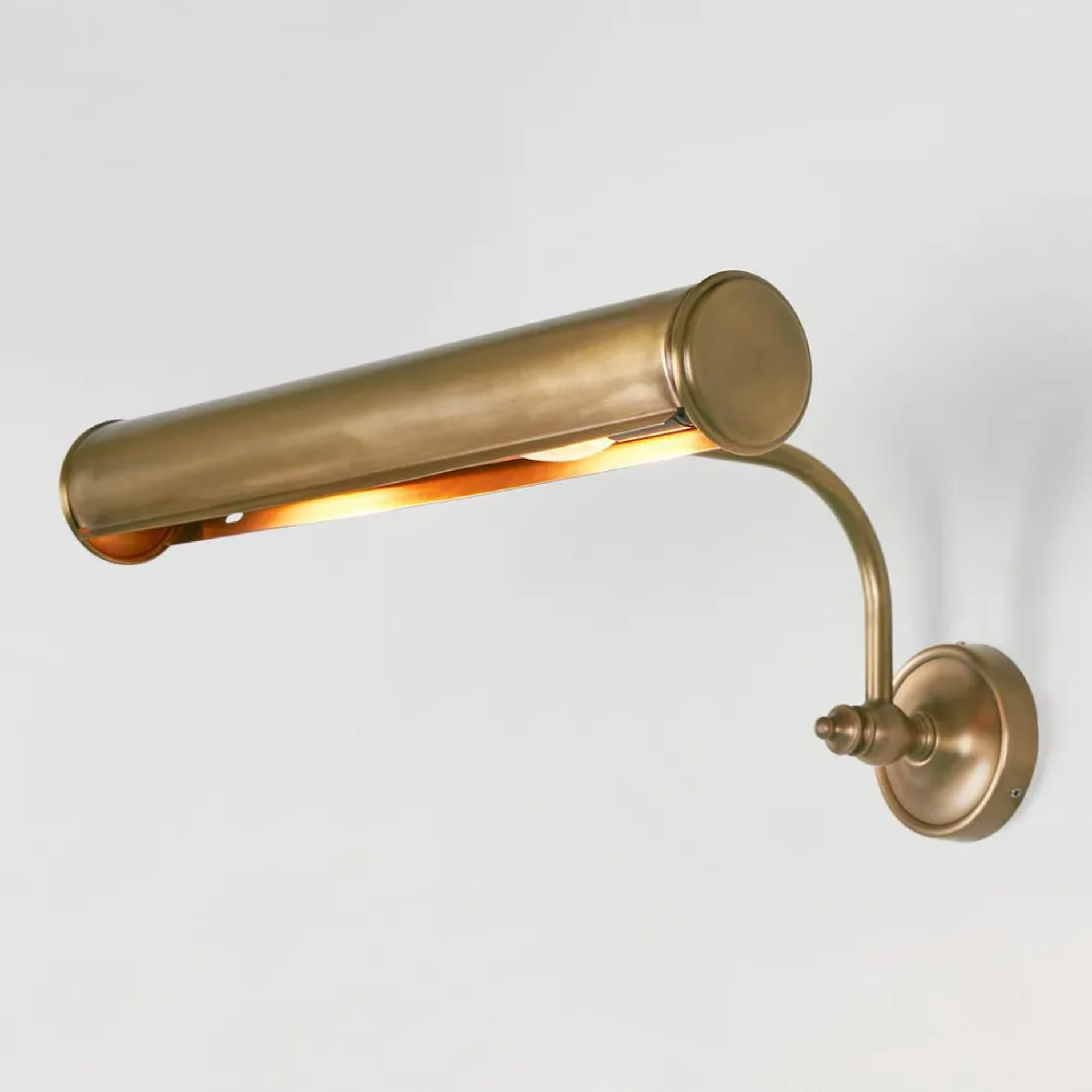 Brass wall-mounted lamp on a light gray background