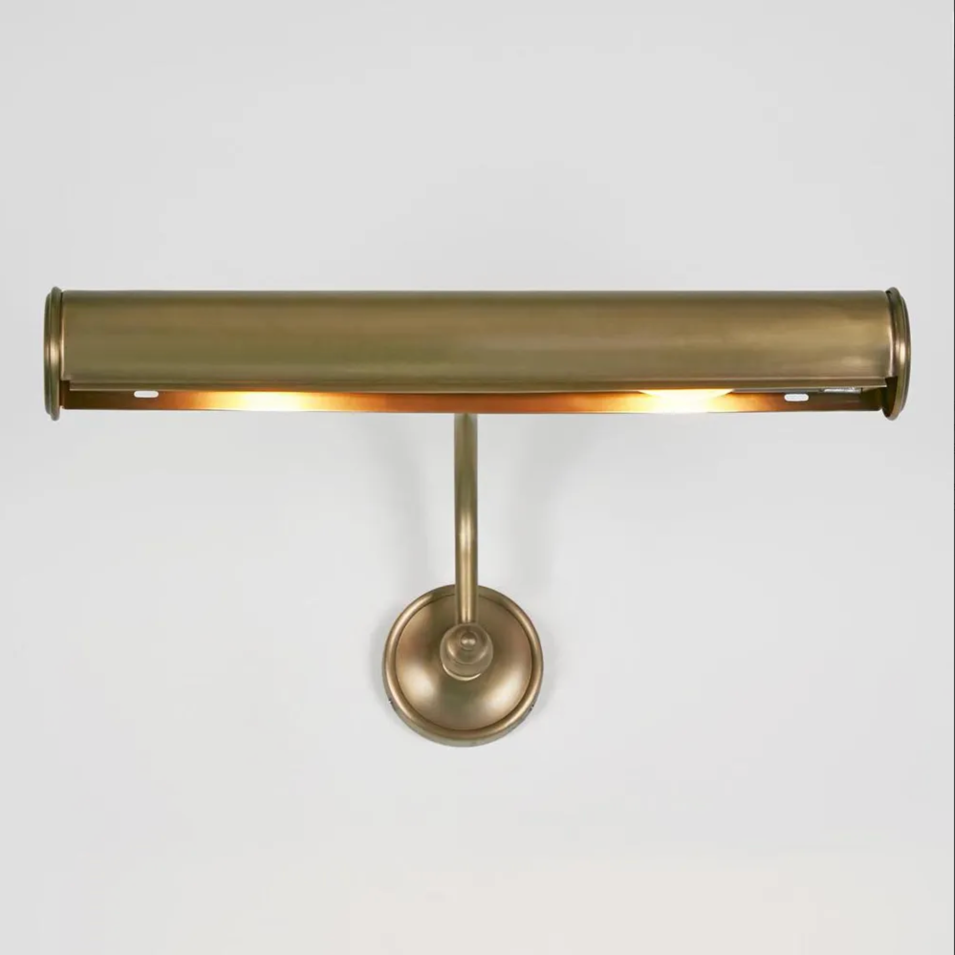 Brass wall-mounted light fixture on a white background