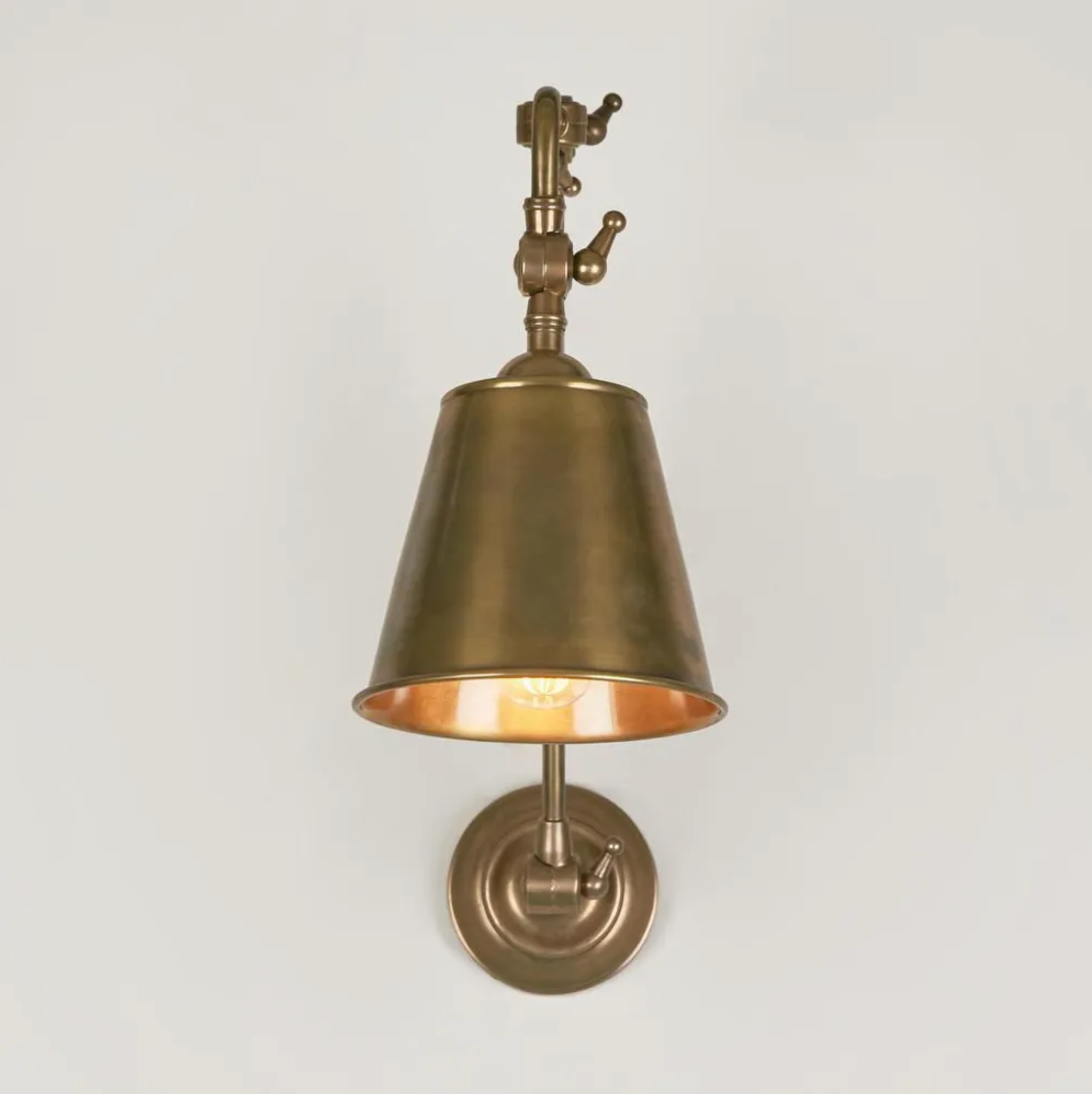 Brass wall sconce on a light gray background