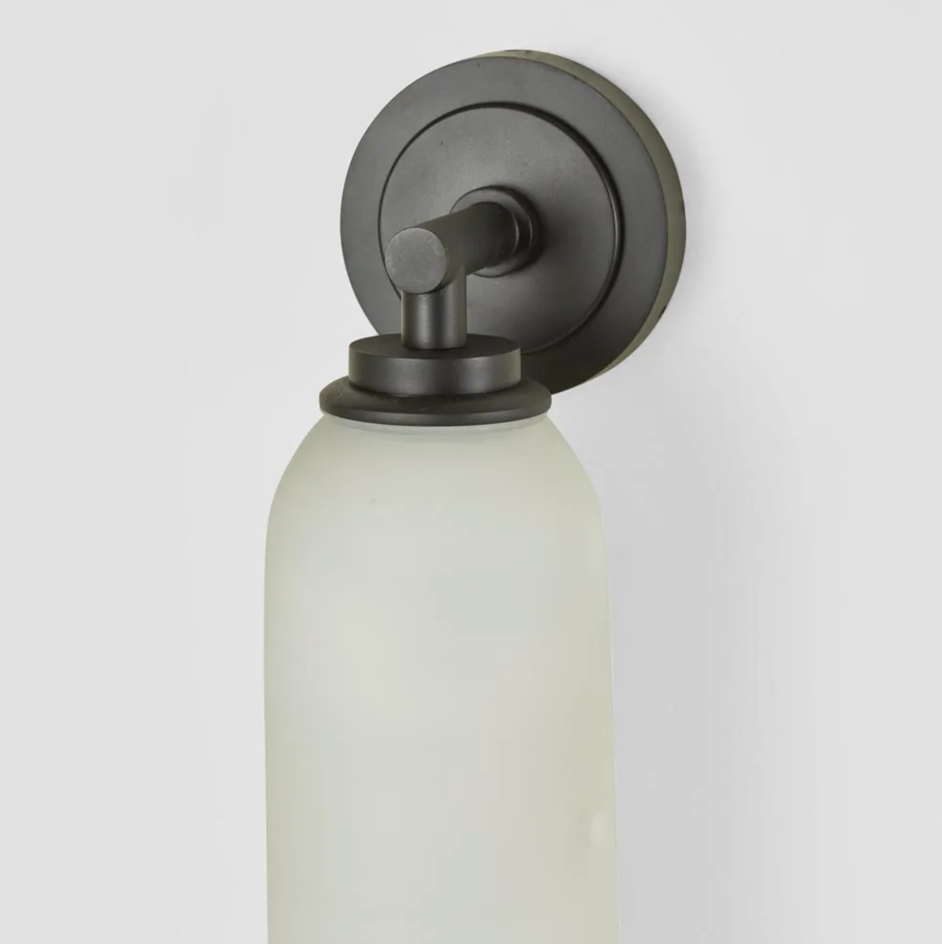 Wall-mounted light fixture with a glass shade on a white background