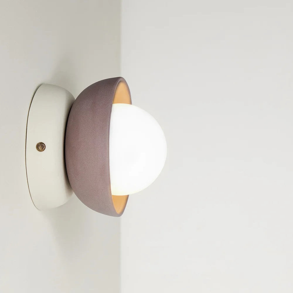 Modern wall light fixture with a white and brown design on a neutral background