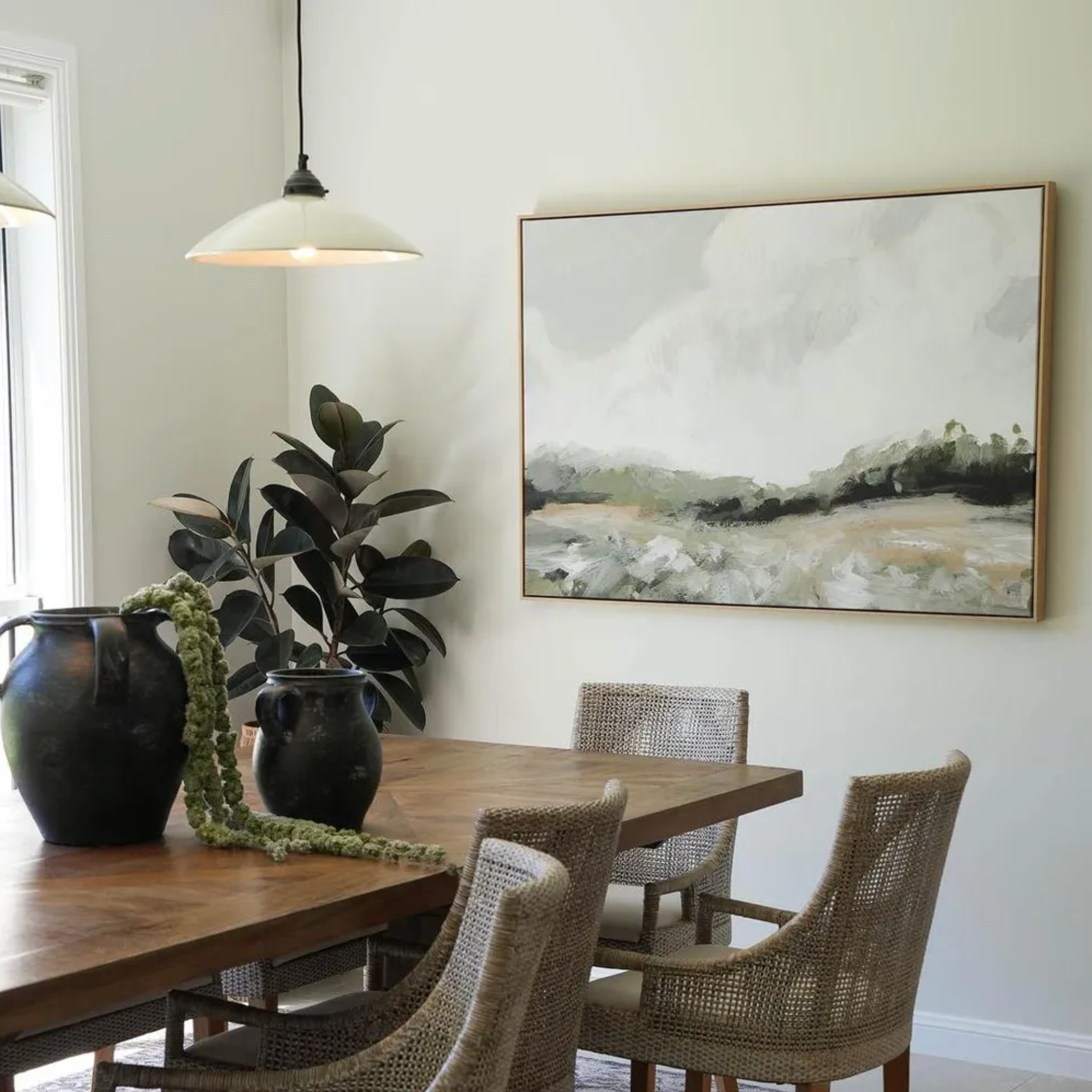 Newport Pendant suspened in dining room over wooden table, chairs, and abstract painting on the wall.