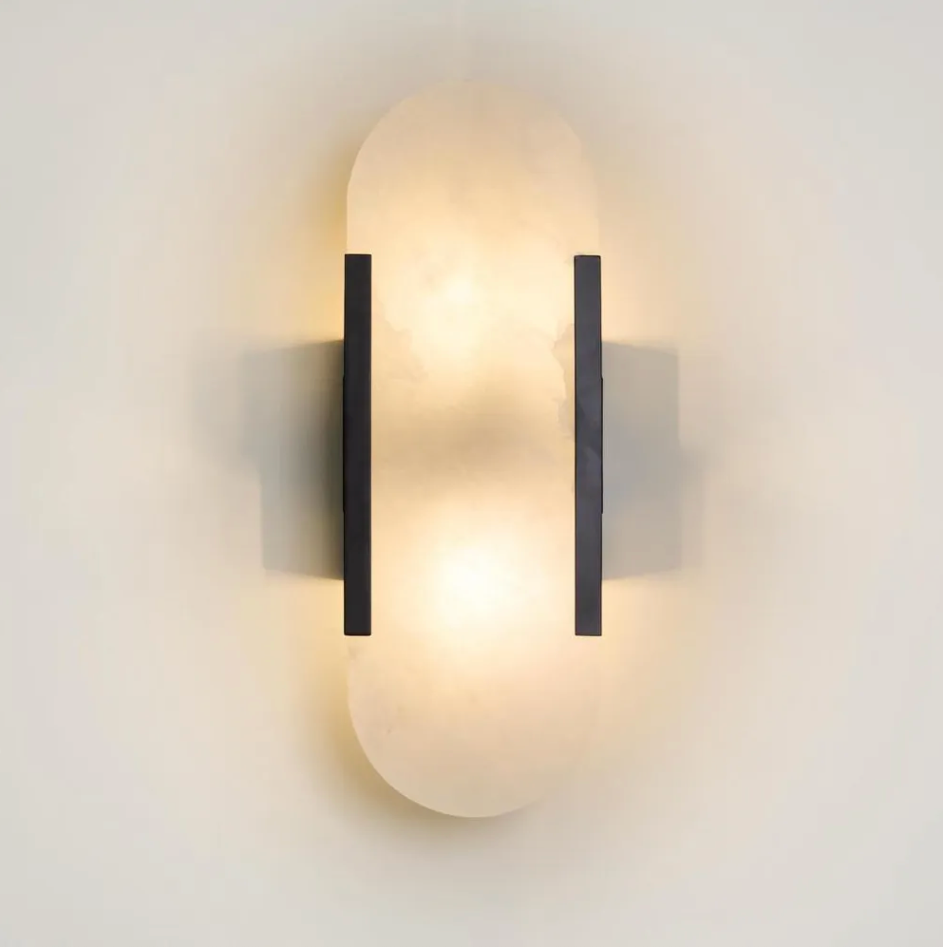 Modern wall sconce with black metal accents on a white wall