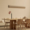 Dining area with wooden table and chairs under a modern pendant light.