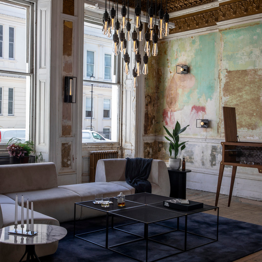 Modern living room with a chandelier, sofa, coffee table, and decorative elements.