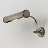 Wall-mounted metal lamp with adjustable arm on a light gray background