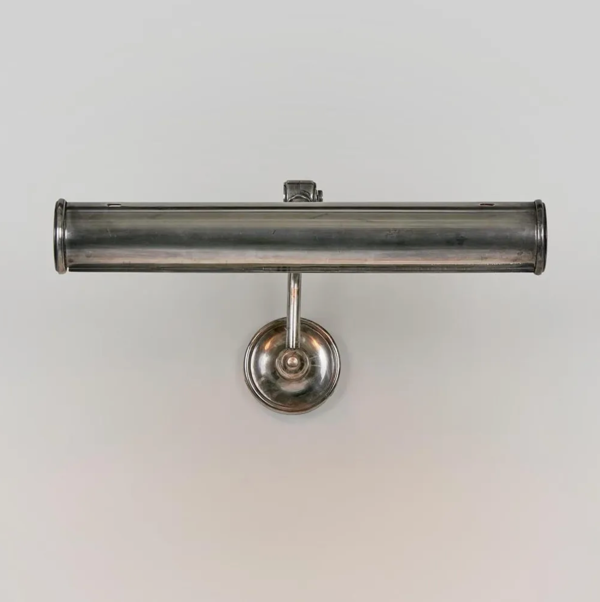 Metallic wall-mounted lamp on a plain background