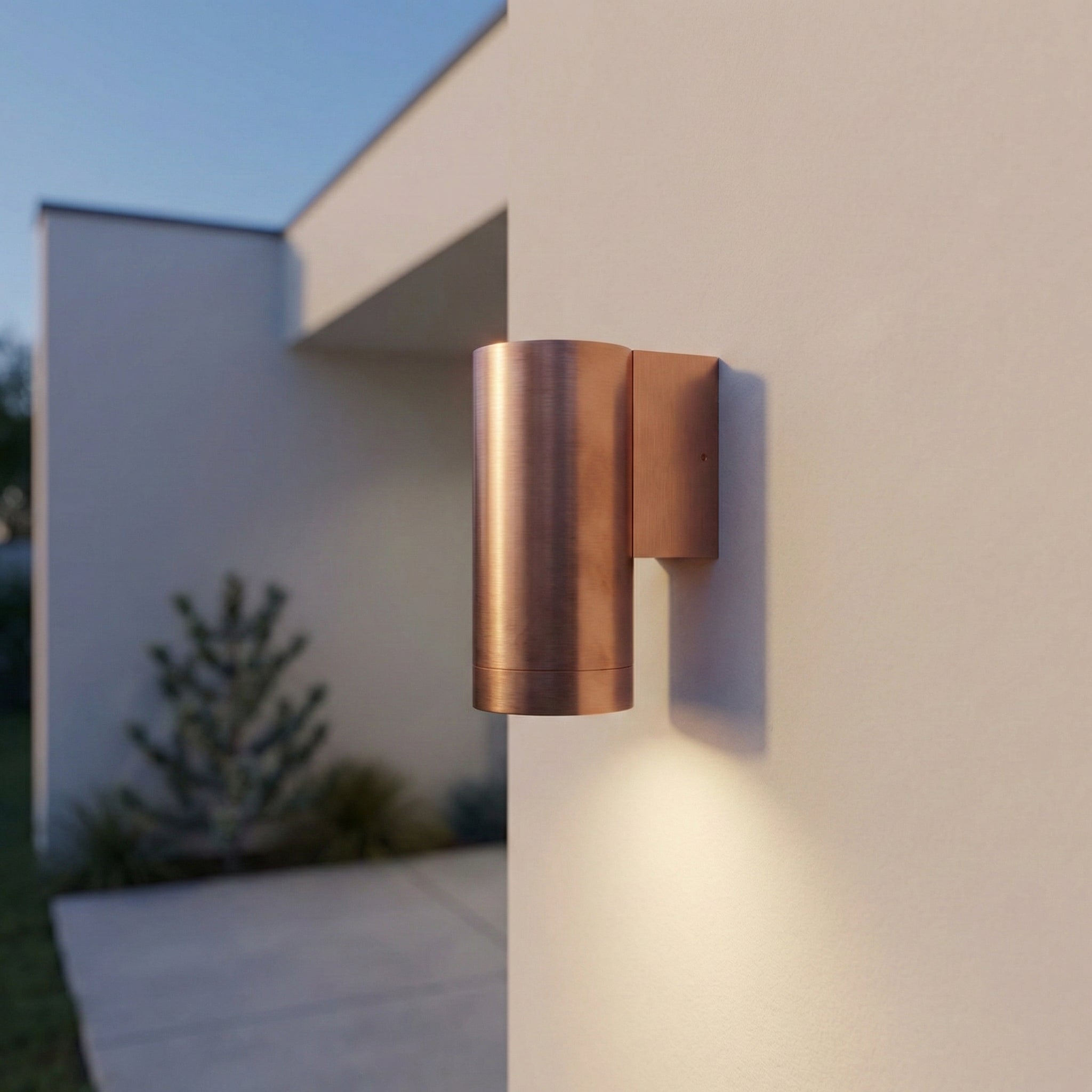 Copper outdoor wall light fixture on a modern building exterior.