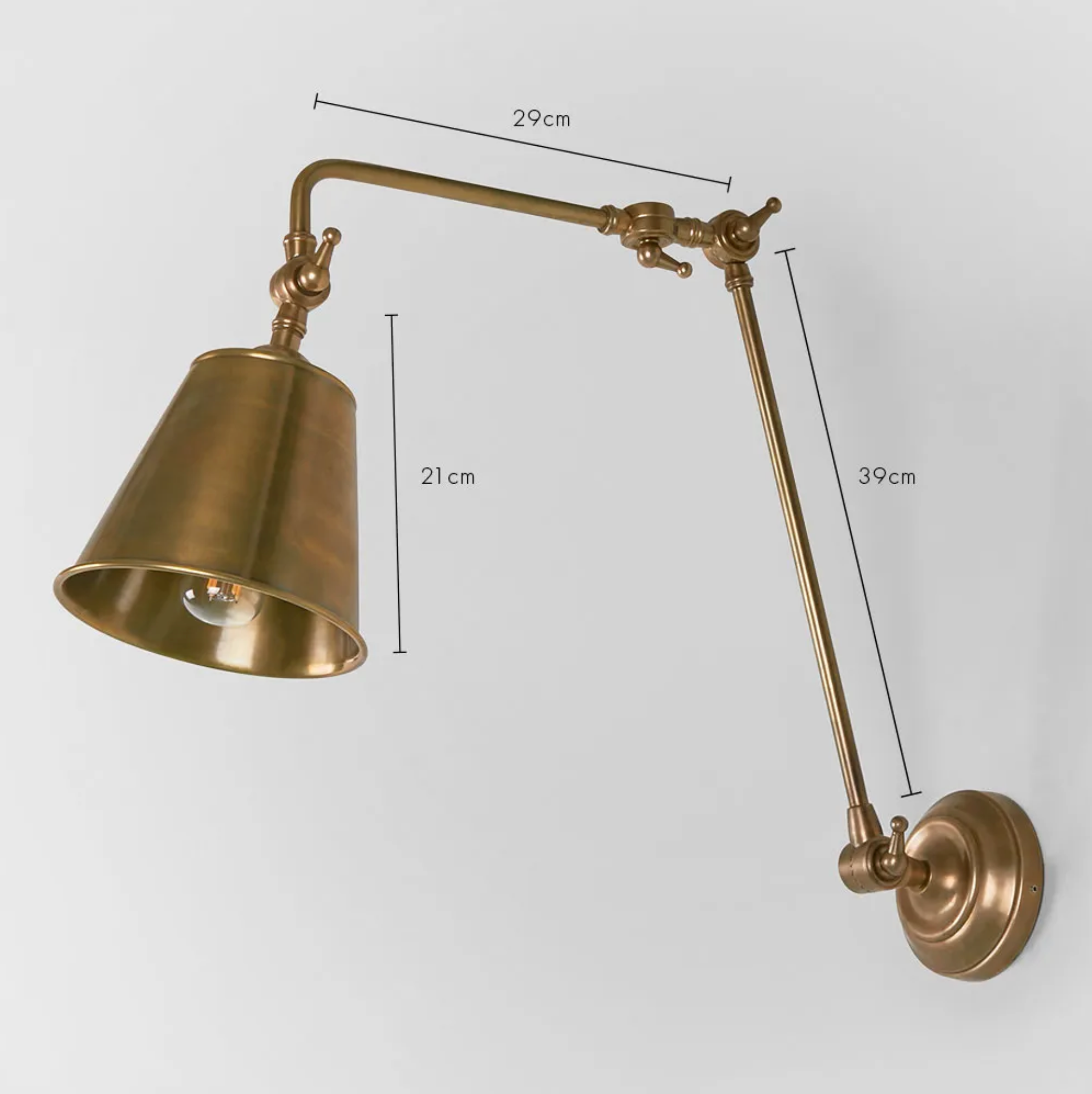 Brass wall lamp with adjustable arm and measurements on a light gray background