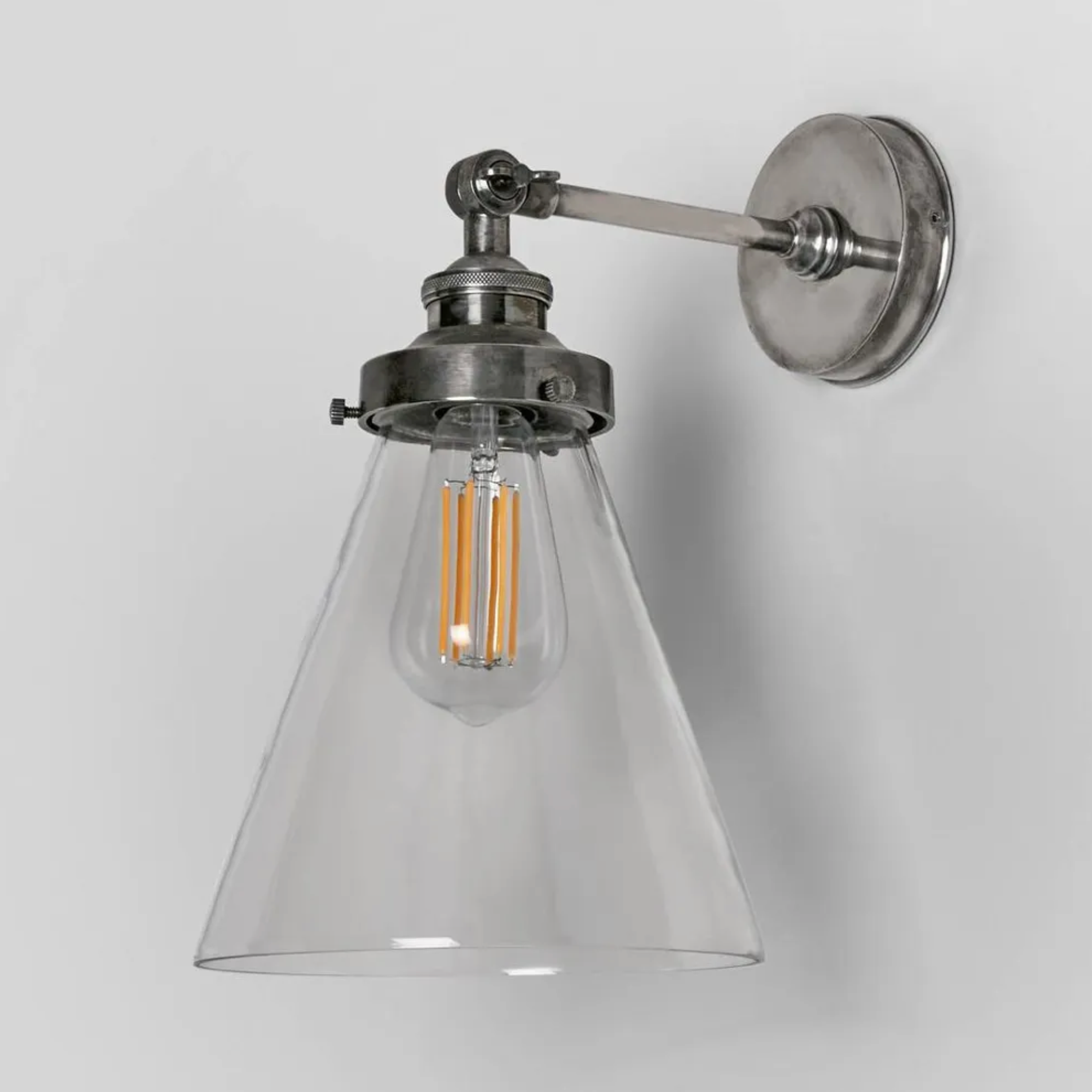 Silver Wall-mounted lamp with glass shade and metallic fixture on a light gray background