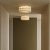 Two ceiling lights in a modern interior setting with a neutral color palette.