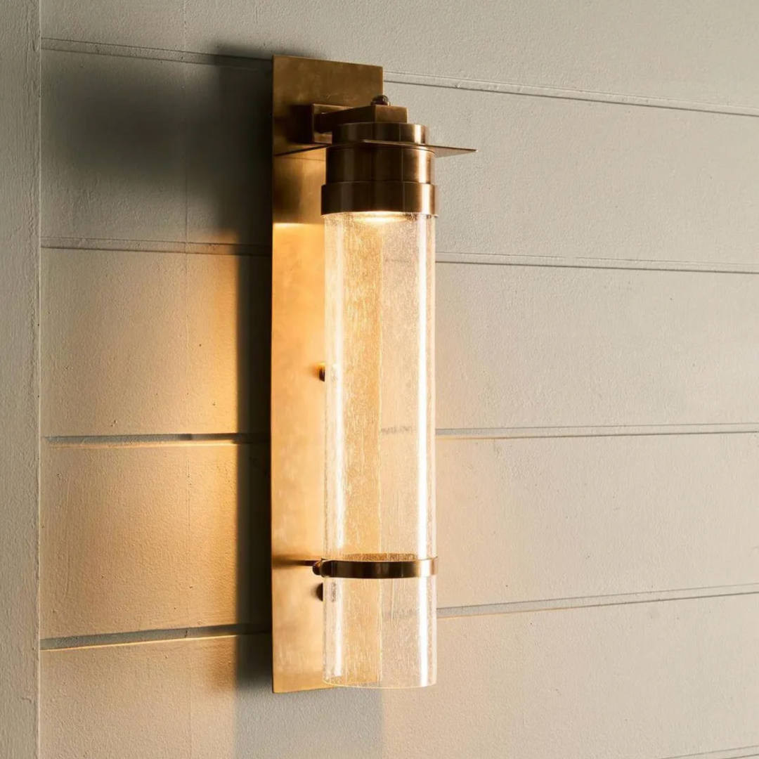 Gold wall sconce on a textured wall