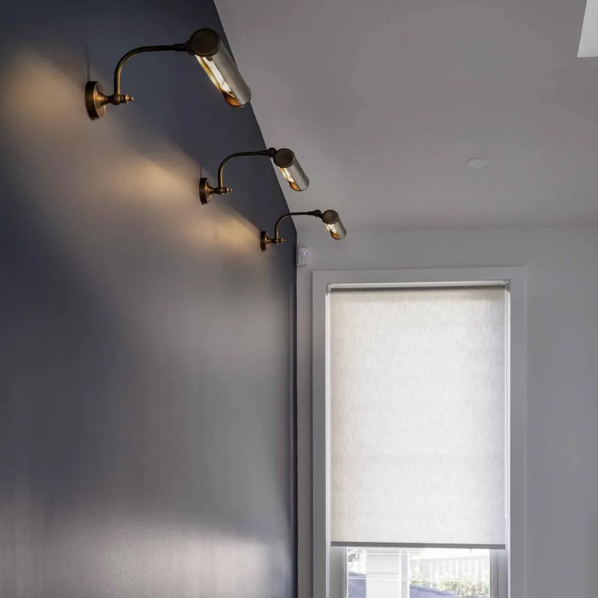 Modern wall lights on a gray wall with a window in the background