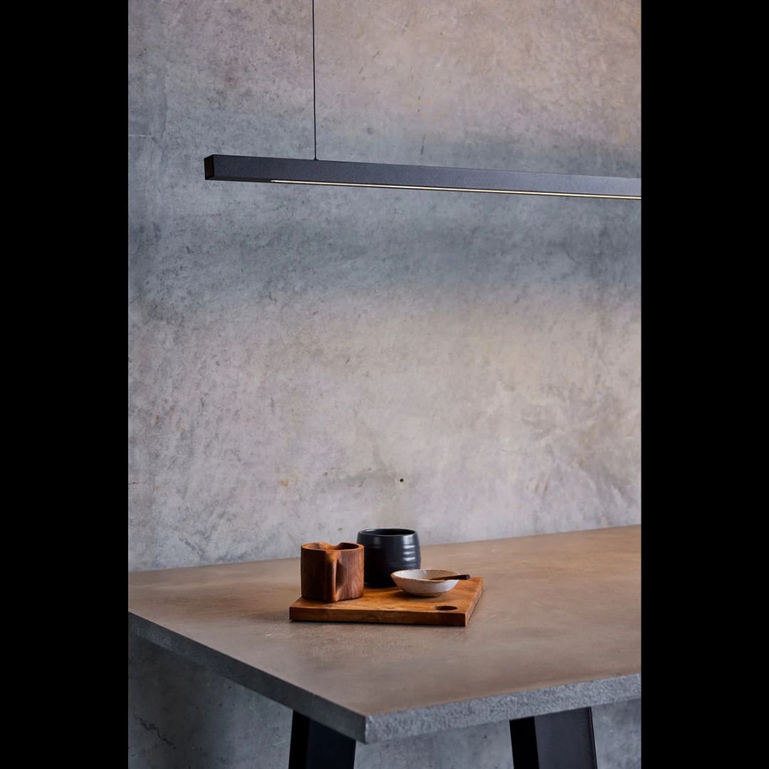 Dining table with ceramic items against a textured wall with the capsuhl black linear light