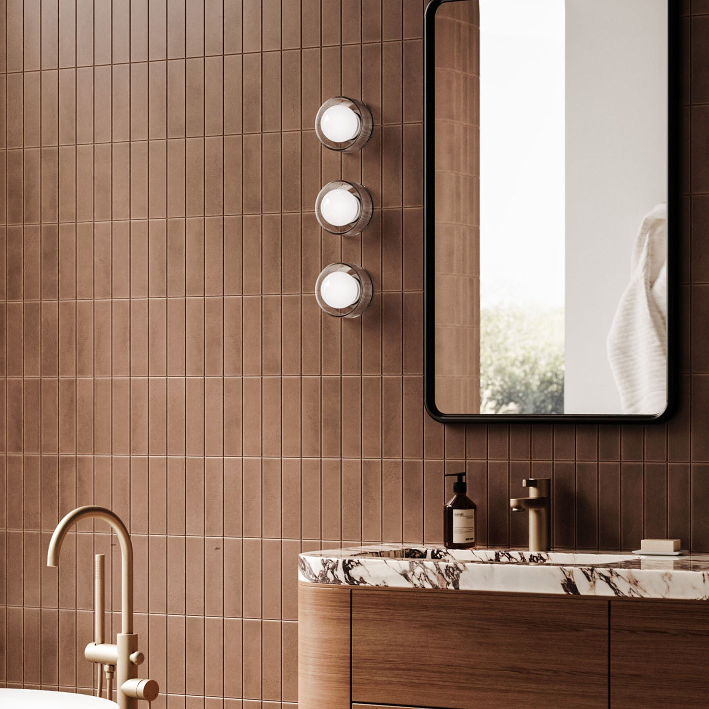 Bathroom interior with brown tiled walls, a mirror, and vanity.