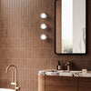 Bathroom interior with brown tiled walls, a mirror, and vanity.