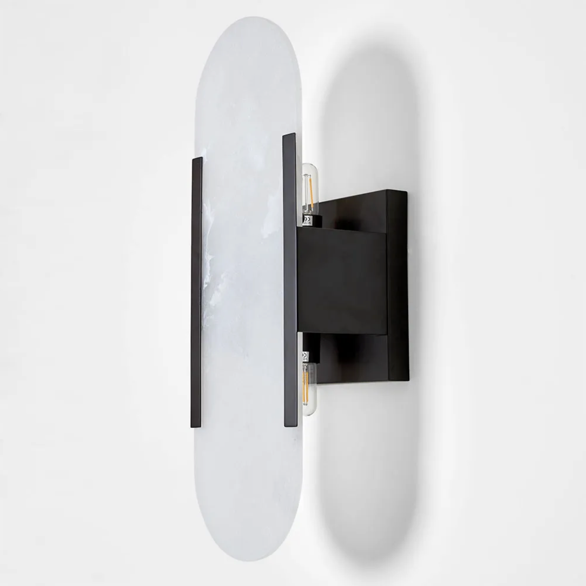 Modern wall sconce with black frame and white glass on a white background